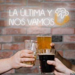 Un grupo de personas sosteniendo vasos de cerveza Neón La Última y Nos Vamos.