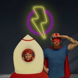Un hombre y un niño vestidos como superhéroes en un cohete con un toque de Neón Rayo, lo que la convierte en una escena digna de IG.