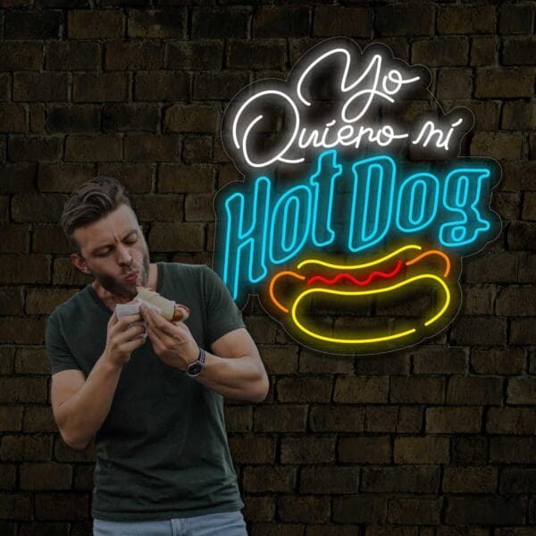 Un hombre disfrutando de un Hot Dog Neón Yo Quiero Mi frente a una pared de ladrillos.