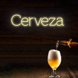 Neón Letrero Cerveza brillando sobre un vaso lleno de cerveza de una botella, contra un fondo de madera.