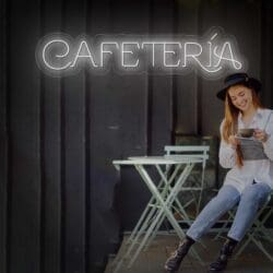 Una mujer joven con sombrero sentada en una mesa de café, sonriendo mientras usa un teléfono inteligente, con "Neon Coffee Shop Letters" brillantes arriba.