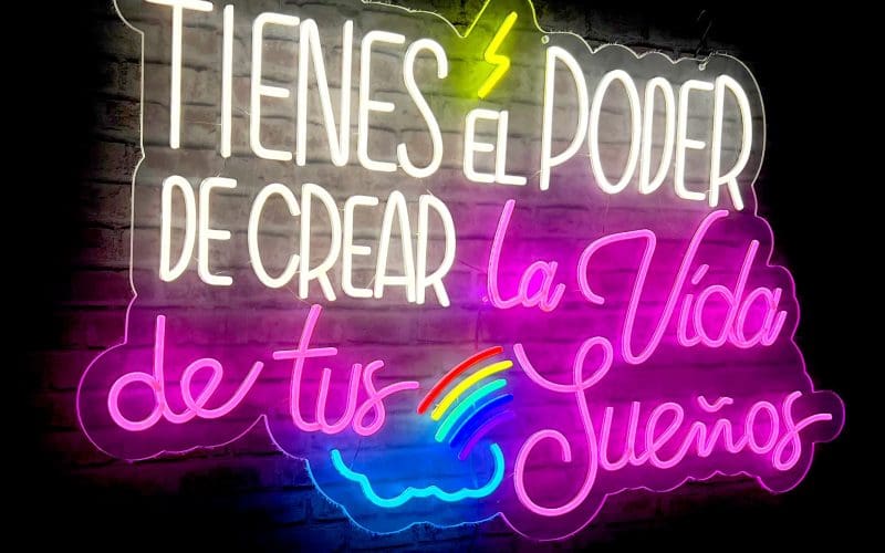 Neón Tienes el poder de crear la vida de tus sueños en la lectura en español, "TIENES EL PODER DE CREAR la Vida de tus Sueños" con detalles coloridos que incluyen un arco iris y formas de corazón.